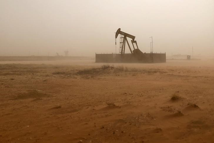 FILE PHOTO: Pump jack lifts oil out of well during sandstorm in Midland