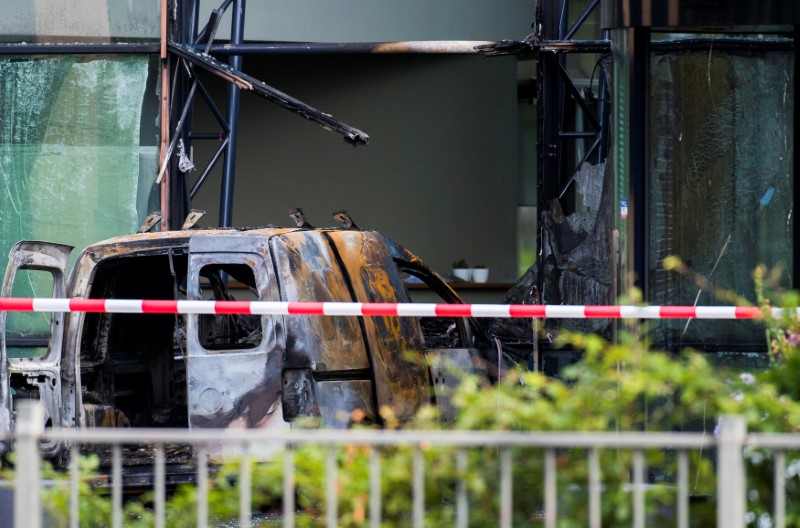 A van is seen burned out after crashing into the glass facade of the head office of Dutch newspaper De Telegraaf in what police said was a deliberate action in Amsterdam