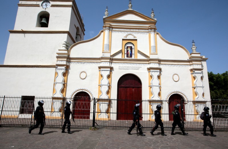 Members of Nicaragua's Special Forces walk past a church during clashes with anti-government protesters in the indigenous community of Monimbo in Masaya