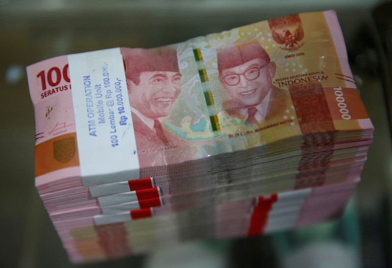 FILE PHOTO: Stacks of Indonesian 100,000 rupiah bank notes are seen on a table in a counting room at Bank Mandiri's headquarters in Jakarta