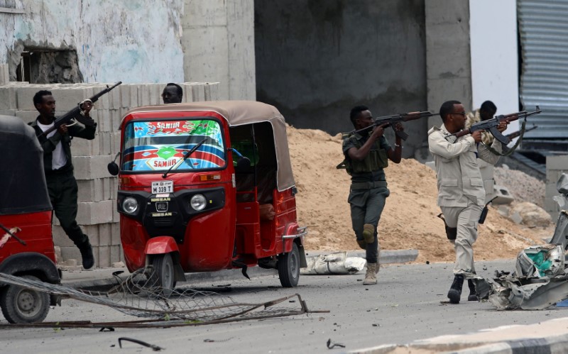 Somali security agents take position as they secure the scene of a suicide car bombing near Somalia's presidential palace in Mogadishu