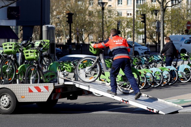 FILE PHOTO: An employee of Velib' Metropole self-service public bike by Smovengo loads a bicycle onto a truck at a distribution point in Paris