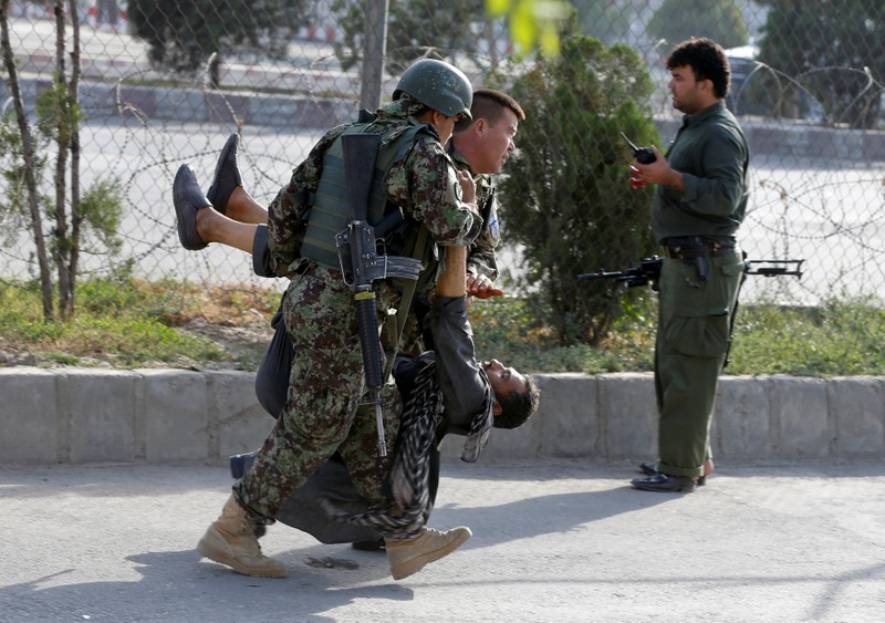 Afghan soldiers carry an injured man after a blast in Kabul