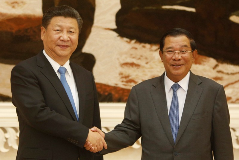FILE PHOTO: Chinese President Xi Jinping and Cambodia's Prime Minister Hun Sen shake hands as they pose for a picture in Phnom Penh