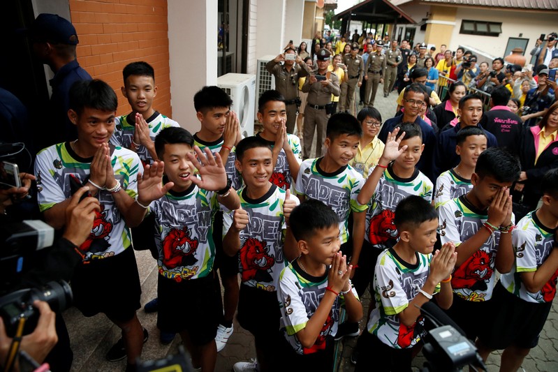 The 12 boys and their soccer coach who were rescued from a flooded cave arrive for a news conference in the northern province of Chiang Rai