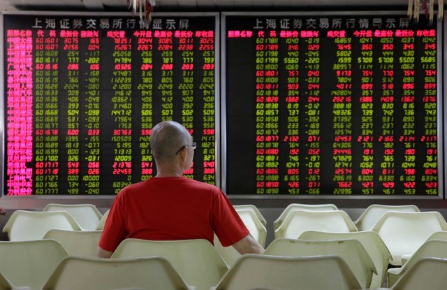 An investor watches stock prices at a brokerage office in Beijing