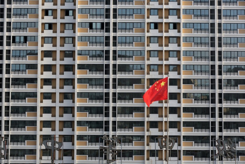 FILE PHOTO: Chinese flag flutters in front of a residential building under construction in Huaian