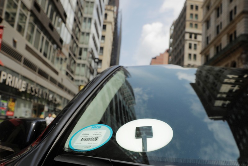 A car with an Uber logo on it drives down the street in New York