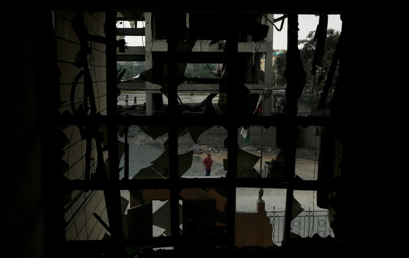 A Palestinian man looks at the Ministry of Religious Affairs that was damaged by Israeli air strikes in Gaza City