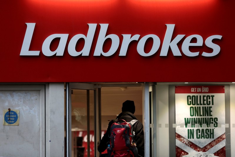 FILE PHOTO: A man walks into a branch of a Ladbrokes bookmaker in London