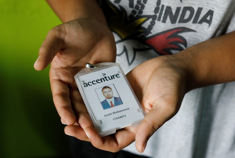 Mohammed Akram, brother of Mohammed Azam, who was killed in a mob lynching attack, poses with the identity card of his deceased brother inside their house in Hyderabad