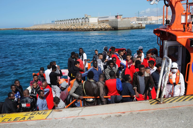 Migrants, intercepted aboard two dinghies off the coast in the Strait of Gibraltar, wait on a rescue boat to disembark after arriving at the port of Tarifa