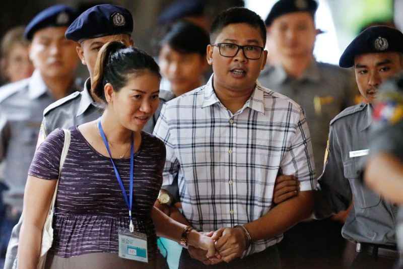 Detained Reuters journalist Wa Lone walks with his wife Pen ei mon as he arrives at Insein court in Yangon