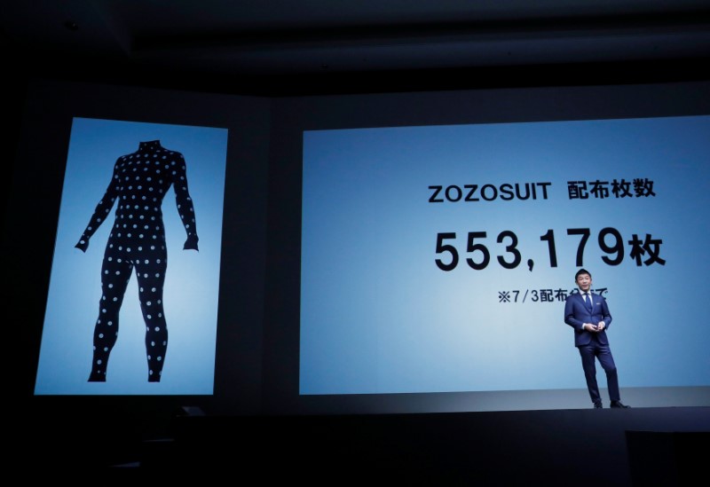 Maezawa, the chief executive of Zozo, which operates Japan's popular fashion shopping site Zozotown, officially called Start Today Co, speaks in front of a projection about Zozosuit at an event launching the debut of its formal apparel items, in Toyko