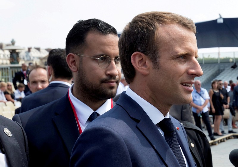 FILE PHOTO: French President Emmanuel Macron walks ahead of his aide Alexandre Benalla at the end of the Bastille Day military parade in Paris