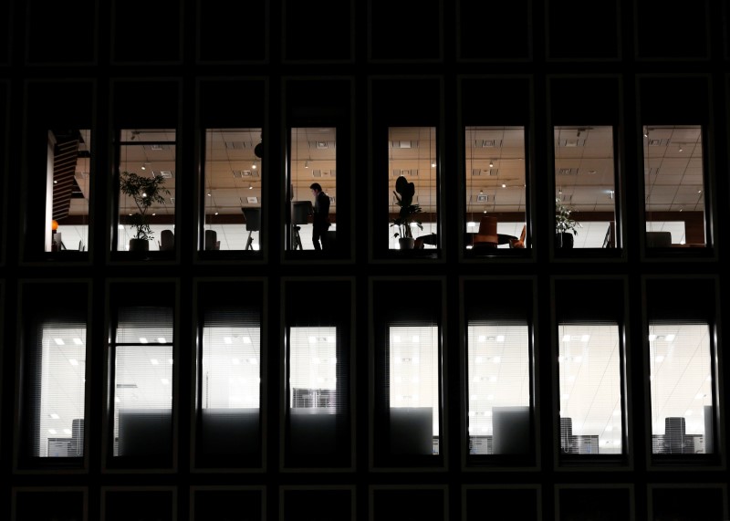 A man is seen at a a commercial building at closing hour at a financial district in Tokyo