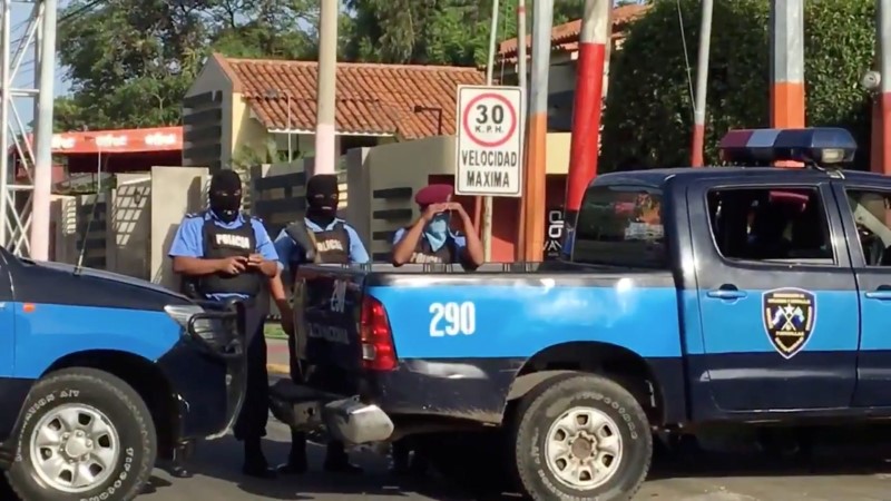 Still image of armed police officers stand nearby while protesters pray in Managua, Nicaragua