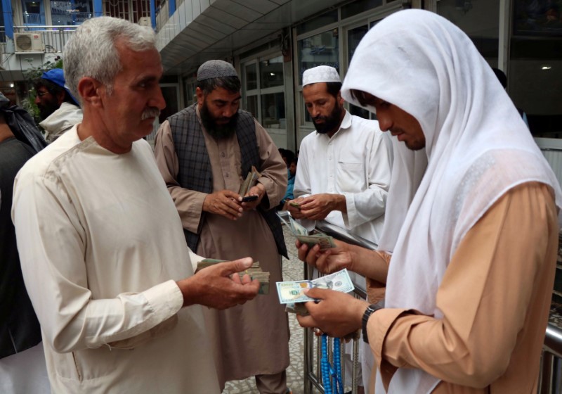 Afghan money changers gather to deal with foreign currency at a money change market in Herat province