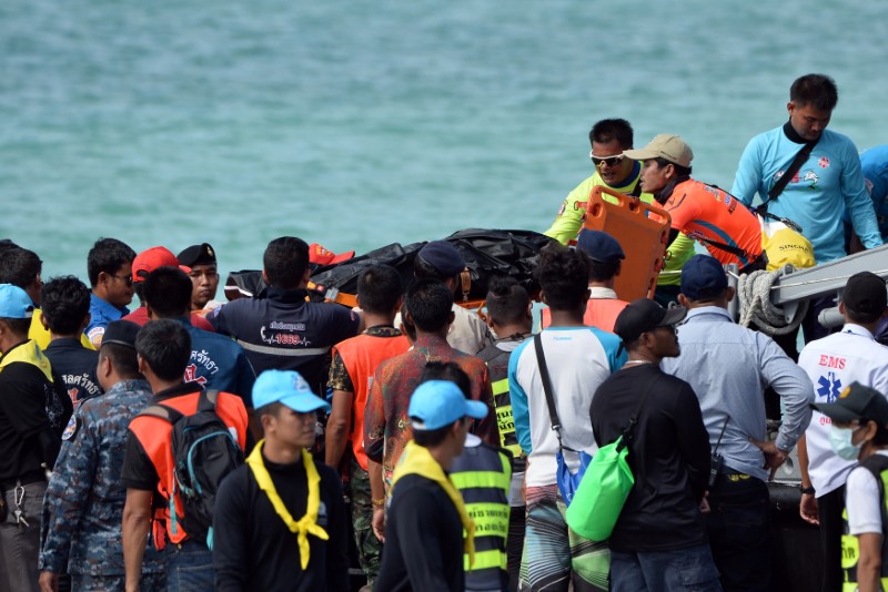 Thai Rescue workers carry the body of a victim on a stretcher, after a boat capsized off the tourist island of Phuket