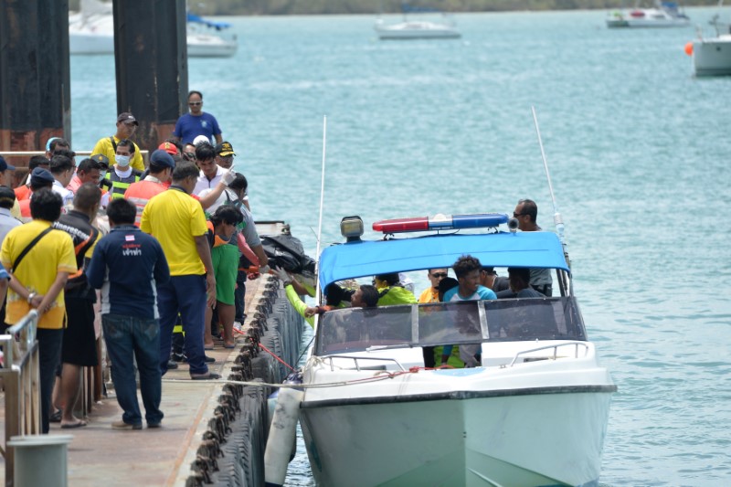 Thai Rescue workers carry the body of a victim on a stretcher, after a boat capsized off the tourist island of Phuket