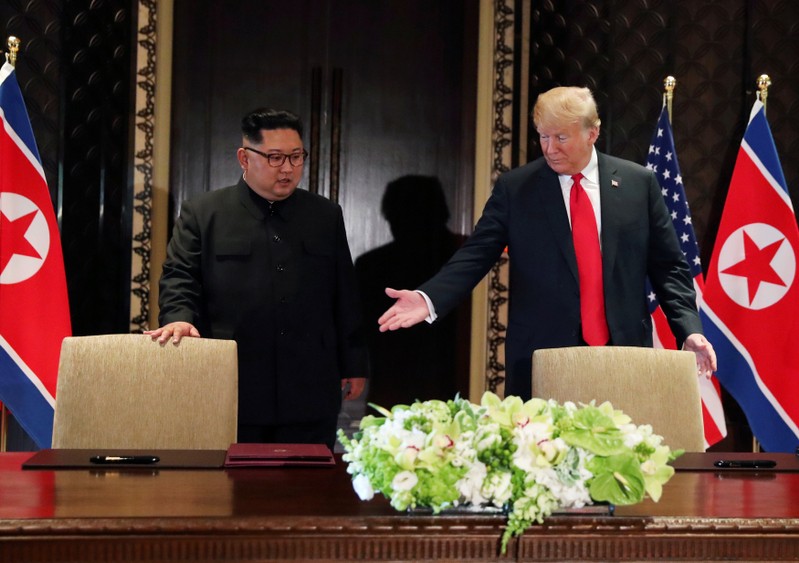 FILE PHOTO: U.S. President Donald Trump and North Korea's leader Kim Jong Un arrive to sign a document after their summit in Singapore