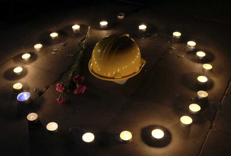 Mining helmet and carnations are seen placed on ground by demonstrators during candlelight vigil for victims of Soma mining disaster, in Istanbul