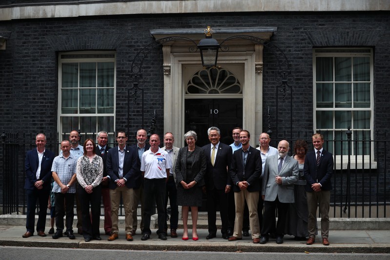 Britain's Prime Minister poses for a photograph with Thailand's Ambassador to the United Kingom, and the British cave diveing team who helped rescue boys from a cave in Thailand, in front of 10 Downing Street, London