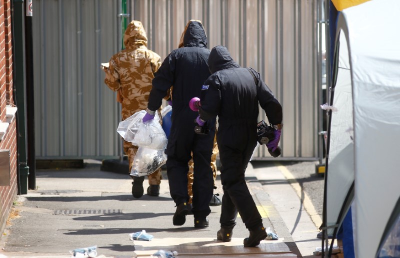 Forensic investigators wearing protective suits enter the rear of John Baker House, after it was confirmed that two people had been poisoned with the nerve-agent Novichok, in Amesbury