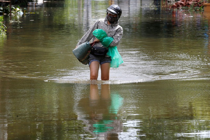 A woman wades through a flooded village after heavy rainfall in Ninh Binh province
