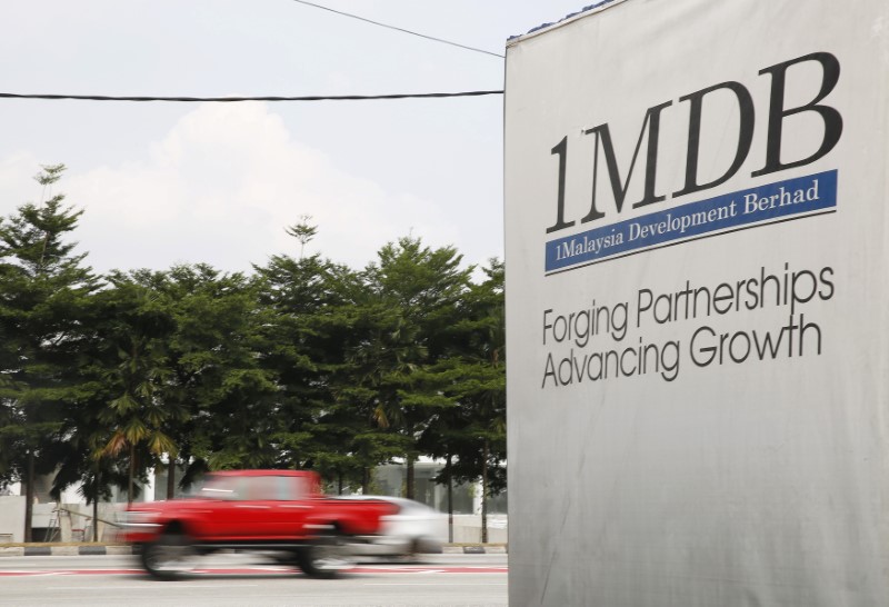 FILE PHOTO: Traffic passes a 1MDB billboard at the Tun Razak Exchange development in Kuala Lumpur