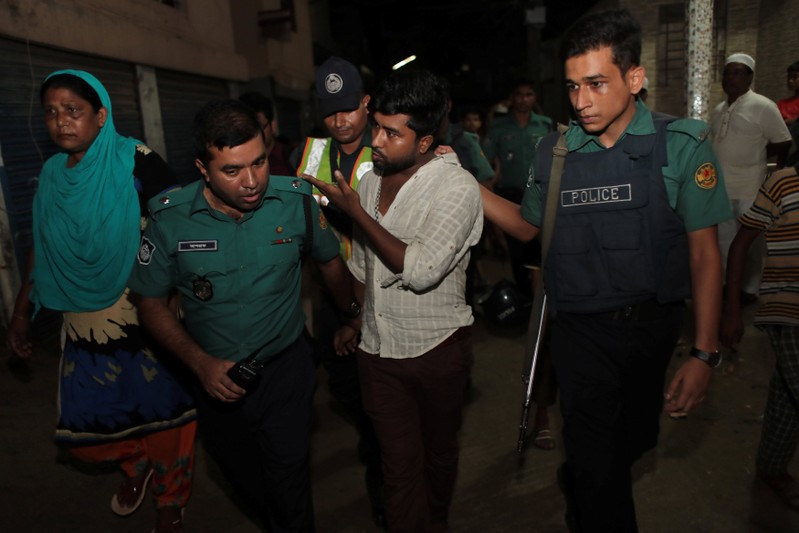Police detain a man, brother of an alleged drug dealer Farhad Hossain Babu, during an anti drug raid in Dhaka