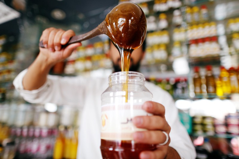 Vendor pours honey at his shop in Sanaa