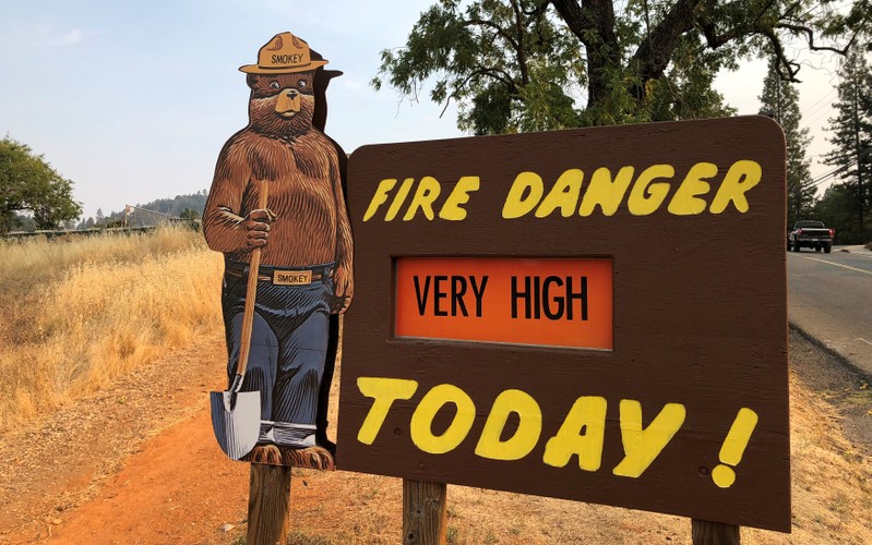 A sign by the side of the road warns of the threat of wildfires which have been fueled by continued hot weather outside the town of Colfax, California