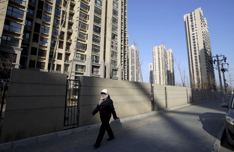 A woman walks past a residential compound in Beijing's Tongzhou district