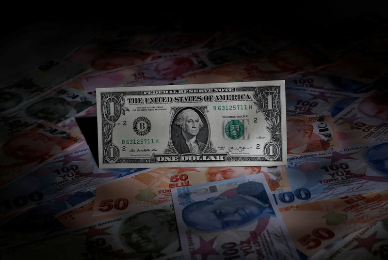 A U.S. dollar banknote is seen on top of Turkish lira banknotes in this picture illustration in Istanbul