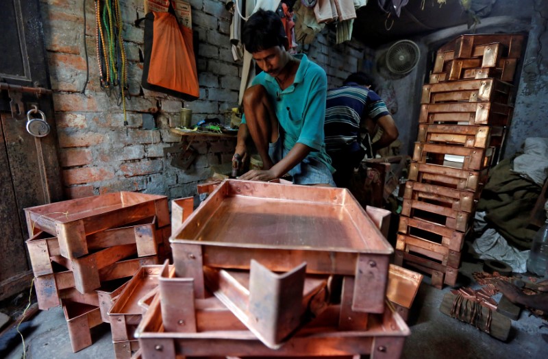 FILE PHOTO: A worker makes copper trays inside a workshop in Kolkata