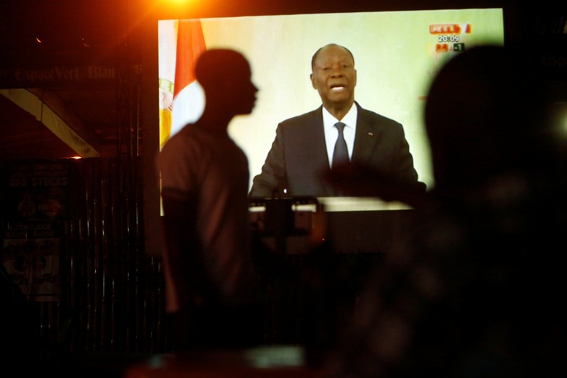 People watch speech of Ivory Coast President Ouattara on a screen in Palmeraie, Abidjan