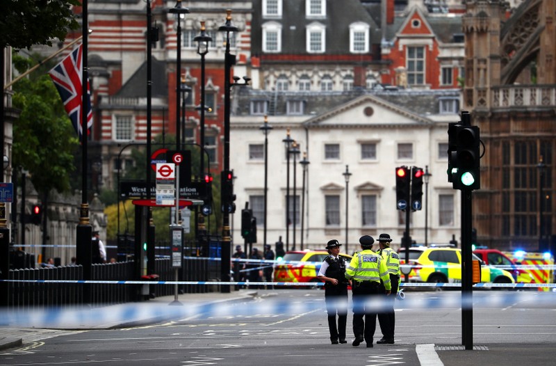 Police stand in the street after a car crashed outside the Houses of Parliament in Westminster, London