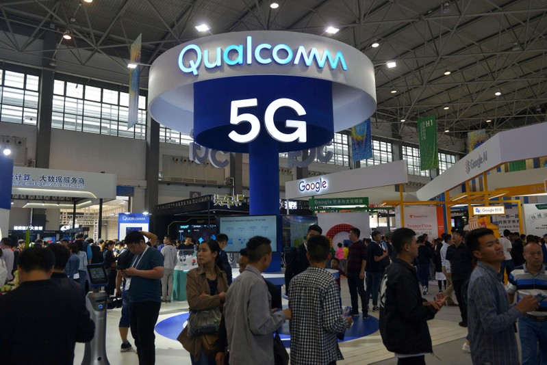 FILE PHOTO: Visitors are seen by a booth of Qualcomm Inc at the China International Big Data Industry Expo in Guiyang