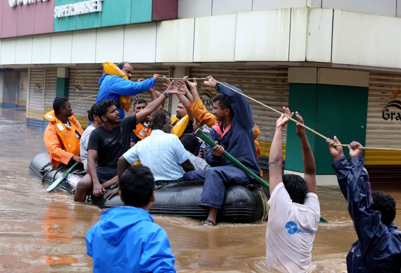 Rescue workers evacuate people from flooded areas after the opening of Idamalayr, Cheruthoni and Mullaperiyar dam shutters following heavy rains, on the outskirts of Kochi