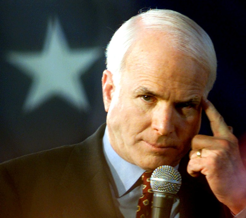 FILE PHOTO - MCCAIN POINTS TO HIS HEAD DURING A RALLY.