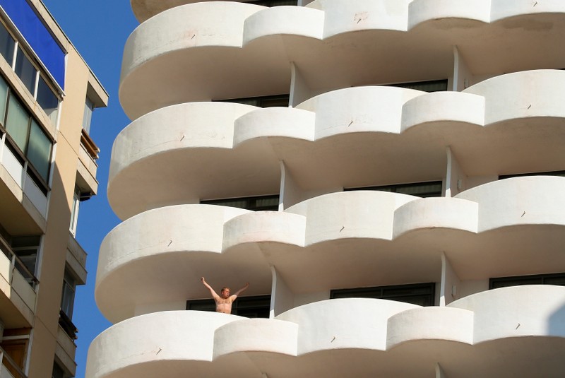 A guest stretches while he stands on a hotel balcony in Palma de Mallorca