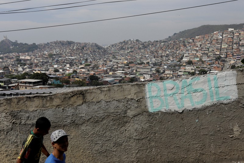 Residents walk at the Chatuba slum in Rio de Janeiro