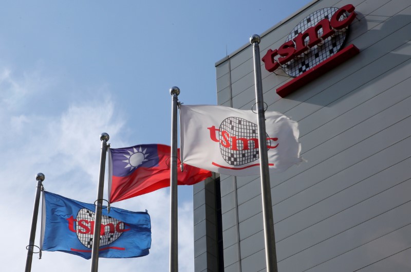 FILE PHOTO: Flags of Taiwan and Taiwan Semiconductor Manufacturing Co (TSMC) are displayed next to its headquarters in Hsinchu