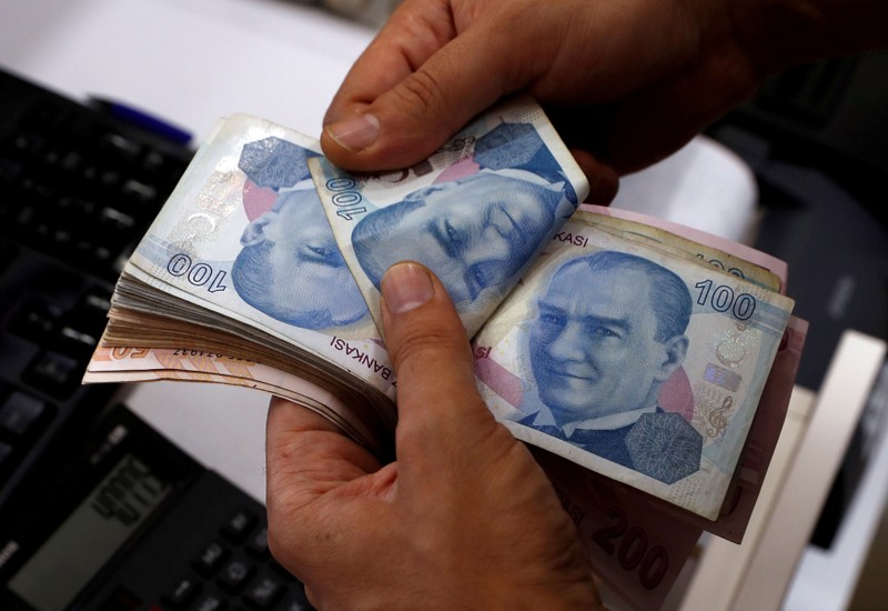 FILE PHOTO: A money changer counts Turkish lira banknotes at a currency exchange office in Istanbul