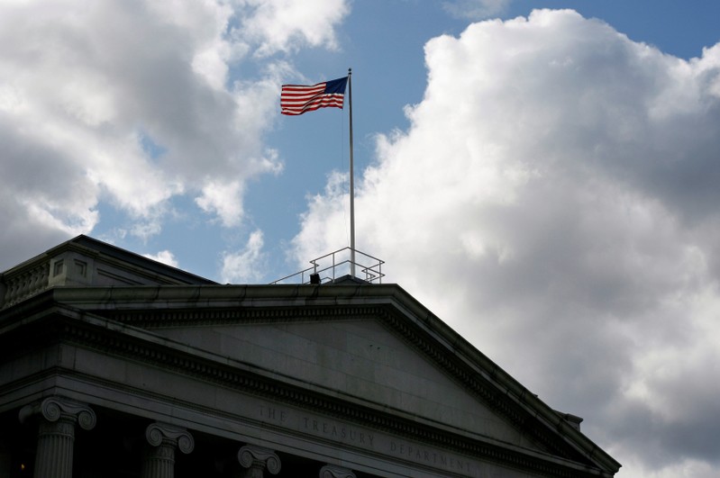 FILE PHOTO: The United States flag flies atop the U.S. Treasury Department in Washington