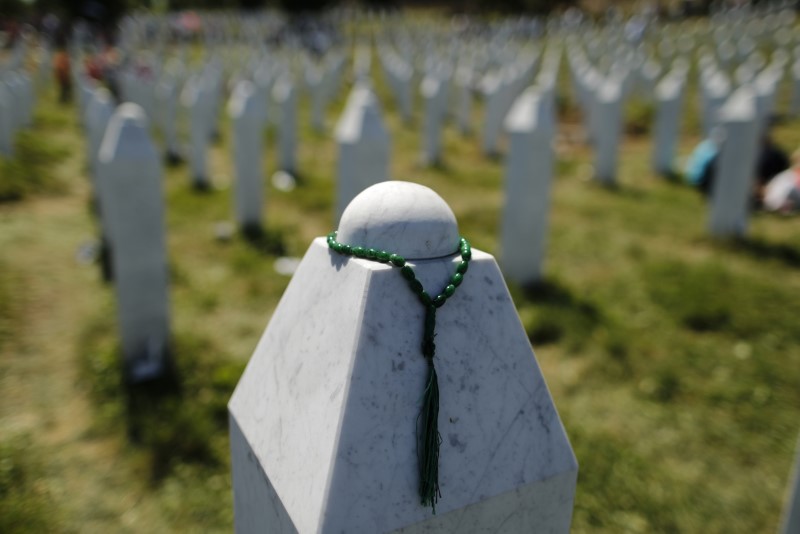 FILE PHOTO - A rosary is placed on a tombstone at the Memorial Center Potocari, near Srebrenica