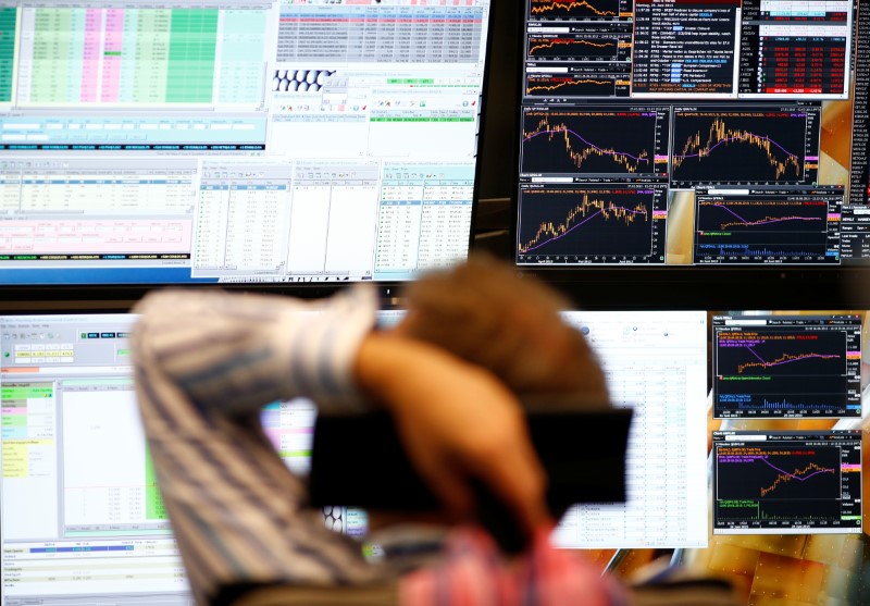 FILE PHOTO: A trader sits in front of the computer screens at his desk at the Frankfurt stock exchange