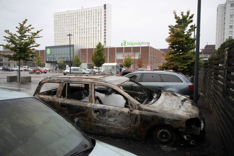 Burned cars are pictured at Frolunda Square in Gothenburg