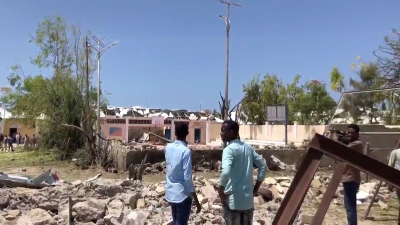 People look at debris at the site of a blast in Mogadishu